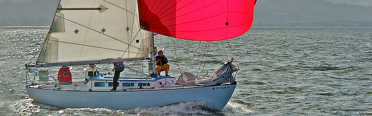 Lapworth 36 Papoose flying a red spinnaker on San Francisco Bay.